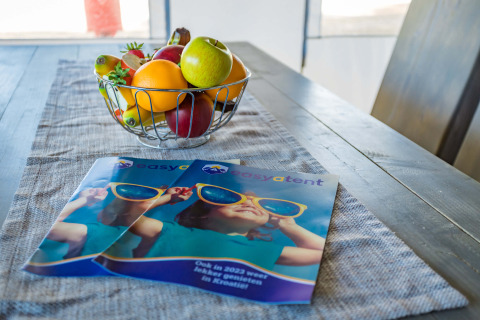 Fruit bowl and brochures on dining table inside Safari Tent Luxury at Camping Lanterna, Croatia.