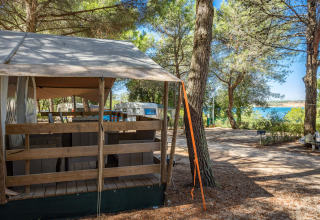 Safari Tent Luxury auf Camping Lanterna in Kroatien mit Blick auf Bäume und das Meer im Hintergrund.