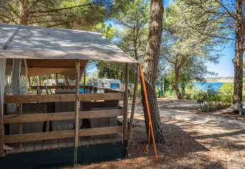 Safari Tent Luxury auf Camping Lanterna in Kroatien mit Blick auf Bäume und das Meer im Hintergrund.
