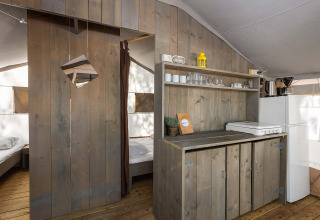Entrada al dormitorio y zona de cocina dentro de una tienda safari de lujo en Camping Lanterna, Croacia.