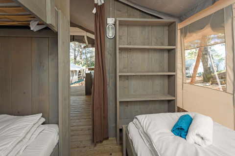 Interieur van de Safari Tent Luxury bij Camping Lanterna in Kroatië met bedden, planken en houten vloer.