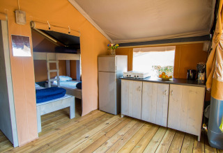 Indretning af Safari tent Comfort med køkken, køleskab og køjeseng på Camping Porto Sole i Kroatien.