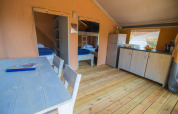 Interior de la tienda Safari Comfort con aire acondicionado, cocina y comedor en Camping Porto Sole, Croacia.
