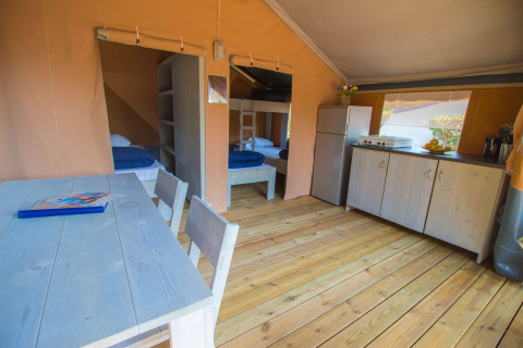 Interior de la tienda Safari Comfort con aire acondicionado, cocina y comedor en Camping Porto Sole, Croacia.