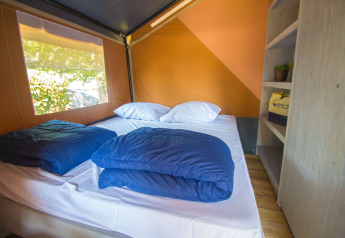Interno della tenda Safari Comfort con aria condizionata e letto matrimoniale al Camping Porto Sole, Croazia.