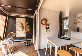 Het interieur van een Cottage Midi Suite safaritent in Papillon Country Resort, modern en gezellig ingericht.
