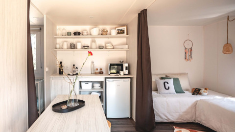 Interieur van Cottage Midi Suite safaritent bij Papillon Country Resort met keuken en bed.