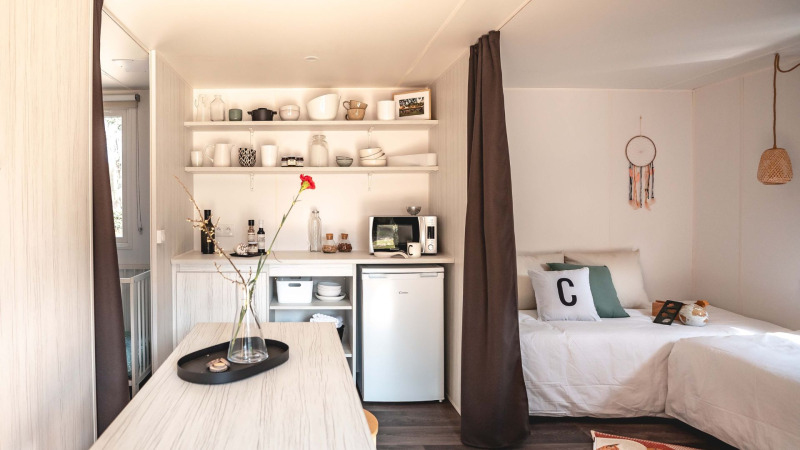 Interior de la tienda safari Cottage Midi Suite en Papillon Country Resort con cocina y cama.