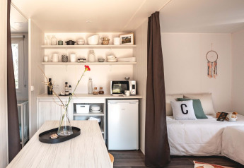 Interior de la tienda safari Cottage Midi Suite en Papillon Country Resort con cocina y cama.