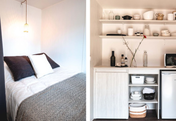 Slaapkamer en kitchenette van Cottage Midi Suite safaritent in Papillon Country Resort, Nederland.