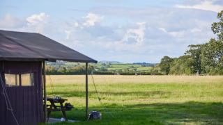 Vista da una tenda safari a Feather Down Mount Pleasant con campi verdi nel Regno Unito.