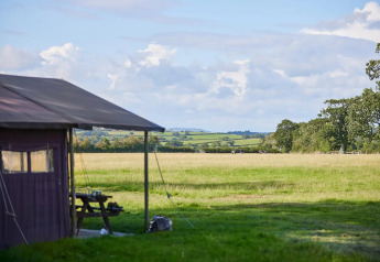 Blick von einem Safarizelt bei Feather Down Mount Pleasant auf grüne Felder in Großbritannien.