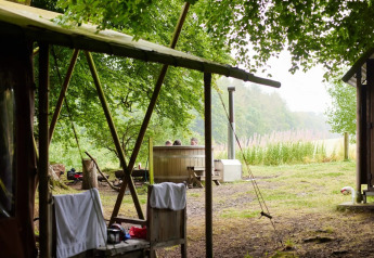 Safari tent cottage with a private hot shower and hot tub at Feather Down Chesters in the United Kingdom.
