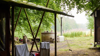 Safari tent cottage with a private hot shower and hot tub at Feather Down Chesters in the United Kingdom.