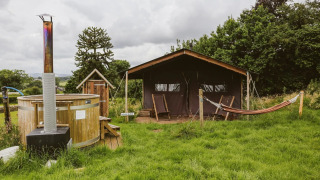 Safari tent with private hot shower, hot tub, and hammock at Feather Down Hollings Hill, United Kingdom.