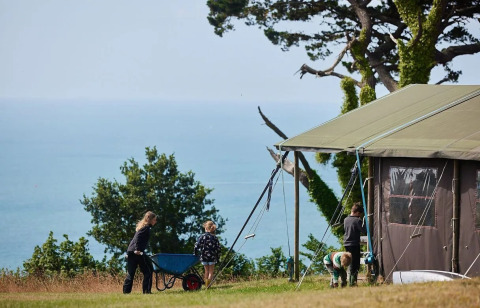 Safari-telt med privat bruser på Feather Down Fountain Violet Farm, med udsigt over havet og naturen.