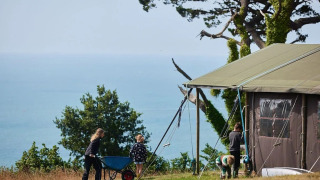 Safari-telt med privat bruser på Feather Down Fountain Violet Farm, med udsigt over havet og naturen.