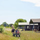 Familie ved safari telt ved Feather Down Glastonbury Hill Farm, Storbritannien, sommerdag med solskin.