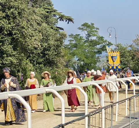 Personas con trajes medievales desfilan en Agriturismo Angeli Sognanti, parque vacacional en Marche, Italia.
