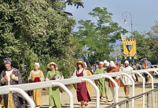 Folk i middelaldertøj går i procession ved Agriturismo Angeli Sognanti, Feriepark, Marche, Italien.