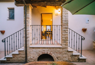 Smuk indgang til en feriebolig med stentrapper og smedejernsgelænder på Agriturismo Angeli Sognanti i Marche, Italien.