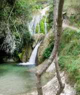 Cascada natural y piscina cristalina rodeadas de vegetación cerca de Cossignano, en la región de Marche, Italia.