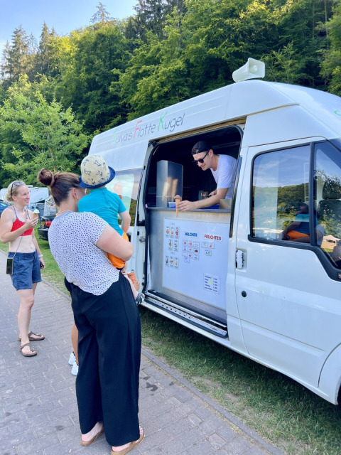 Famiglia prende il gelato da un furgone a Camp Kyllburg, villaggio vacanze in Renania-Palatinato, Germania.