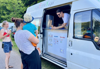 Familie kauft Eis an einem Eiswagen im Ferienpark Camp Kyllburg in Rheinland-Pfalz, Deutschland.