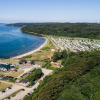 Aerial view of Rosenvold Strand Camping in Denmark with campsite, beach, forest, and marina visible.