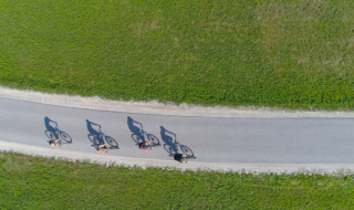 Vue aérienne de quatre cyclistes sur une route entourée de verdure près de Stouby, Danemark central.