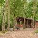 Safari teltkøje ved Feather Down Layer Marney Tower, UK, omgivet af træer med privat bad og spabad.