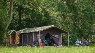 Safari-tent met privé warme douche naast de tent bij Feather Down Moor Farm, UK, familie aan picknicktafel.