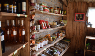 Tienda rústica con estantes de madera, productos locales y vino en Feather Down La Ferme de Penquelen Huella, Bretaña.