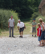 Familia disfruta de un juego de petanca al aire libre en Feather Down La Ferme de Penquelen Huella en Bretaña.