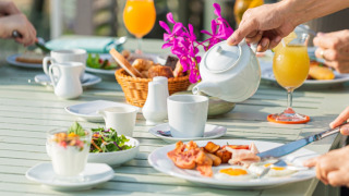 Outdoor breakfast scene at Woodz Lodges holiday park in Limburg, Belgium, with juice and fresh food.