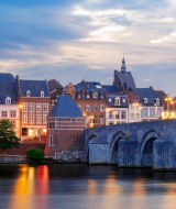 Evening view of charming buildings and an old stone bridge over the river near Heusden-Zolder, Belgium.