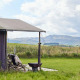 Safari-telt ved Feather Down Pant y March Farm i Storbritannien med udsigt over grønne marker og bakker.
