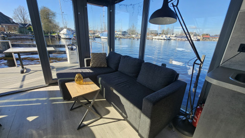 Salon du Houseboat Heeg à la Marina Heeg, Pays-Bas, avec vue sur l'eau et le port de plaisance.