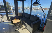 Stue på husbåd Houseboat Heeg ved Marina Heeg i Holland med udsigt over vandet og havnen.
