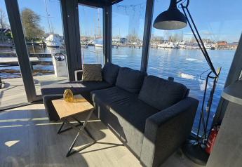 Wohnbereich auf dem Hausboot Houseboat Heeg im Yachthafen Heeg, Niederlande, mit Blick aufs Wasser.