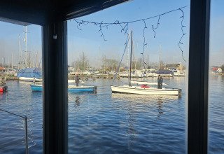 Vista dalla Houseboat Heeg a Marina Heeg, Paesi Bassi, con piccole barche a vela e il porto turistico.