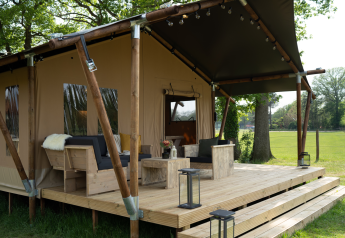 Tenda safari con bagno privato e terrazza extra grande presso Holiday Park Mölke nei Paesi Bassi, immersa nel verde.