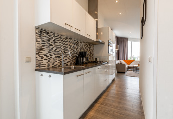 Moderne lodgekøkken med mosaikfliser og opholdsstue på Resort Mooi Bemelen, Biebosch, Nederlandene.