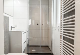 Bagno moderno al Biebosch, Resort Mooi Bemelen, Paesi Bassi, con doccia, lavabo e WC sospeso.