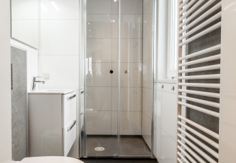 Moderne badkamer bij Biebosch, Resort Mooi Bemelen in Nederland, met douche en zwevend toilet.