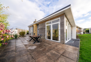 Moderne lodge met terras en grote glazen deuren bij Resort Mooi Bemelen, Nederland, Biebosch - Sunshower.