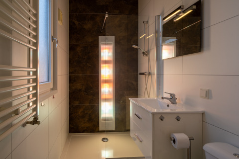 Baño moderno con ducha solar y decoración elegante en Biebosch - Sunshower, Resort Mooi Bemelen, Países Bajos.