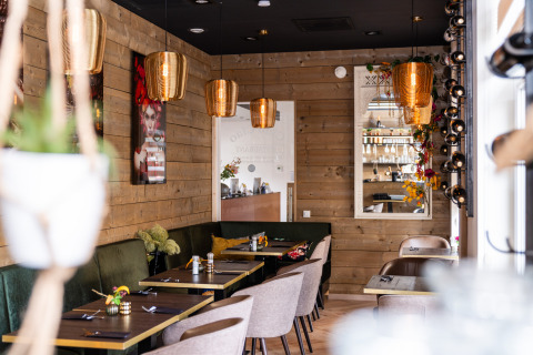 Stijlvol lodge restaurant met houten panelen en gouden verlichting bij Biebosch - Sunshower, Resort Mooi Bemelen.