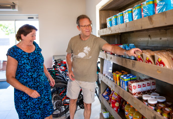 To personer handler ved en træhylde med snacks i Biebosch - Sunshower på Resort Mooi Bemelen, Holland.