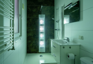 Baño moderno en Biebosch - Sunshower en el Resort Mooi Bemelen en los Países Bajos con ducha y lavabo.